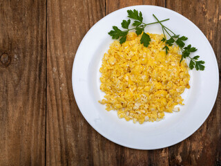 fresh scrambled eggs on white plate on breakfast table