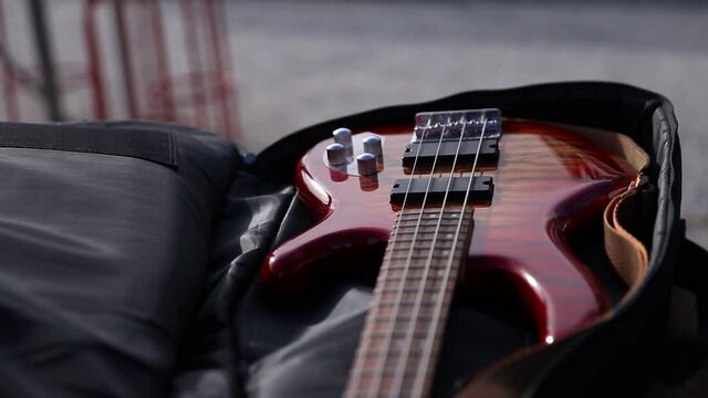 Hands takes bass guitar from case 2