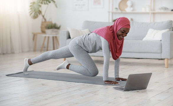 Home Sport For Muslim Women. Lady In Hijab Excersing In Living Room