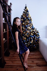 
girl in the studio on the background of a Christmas tree