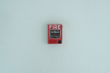 A texture and backgrounds a fire pull down  button on the building wall.