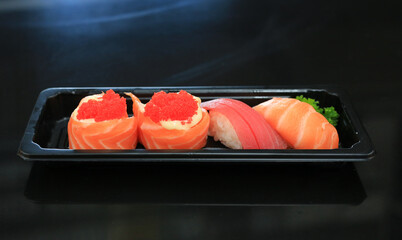 Close-up Sushi seafood set on black tray on black table. Japanese food cuisine