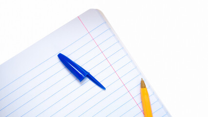 A yellow pen with a blue open cap lying on a notebook in line.