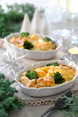 Homemade gratin with shrimp and cheese in baking dishes on Christmas decoration table.　マカロニグラタン