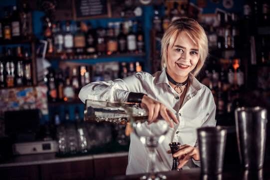 Girl bartender concocts a cocktail at the public house