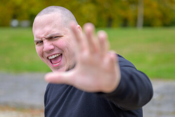 Angry young man shouting and gesturing with a hand