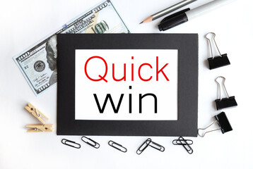 QUICK WIN, text on white paper in a black frame on a light background