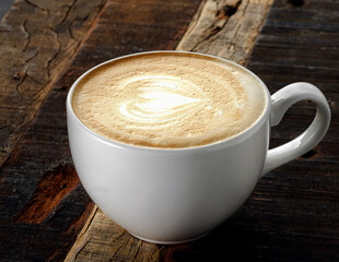 Coffee mug on wooden table in rustic style, cappuccino with heart on foam