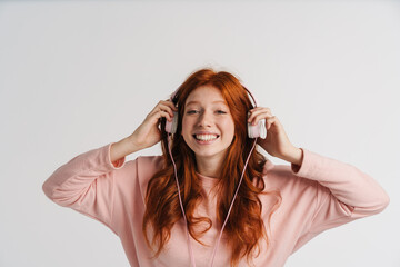 Ginger beautiful happy girl listening music with headphones