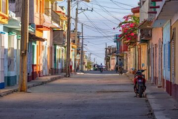 A dirty street with beautiful bright colors and interlacing wires. Cuba, Trinidad.