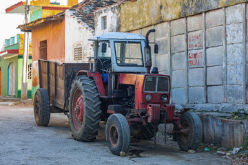 Fototapeta na wymiar Old Soviet tractor MTZ-80 on the streets of the dirty city of Trinidad in Cuba!