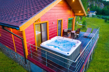 House with a place for spa. Hot tub is located on terrace of the cottage. Swimming pool with hydromassage. On terrace of house - place for relaxation. Open-air bath. Bathtub for spa treatments.