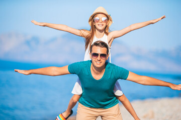 Little girl and happy dad having fun during beach vacation