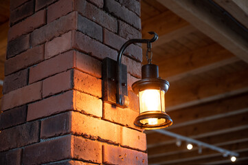rustic lamp shines with light bulb on a brick wall