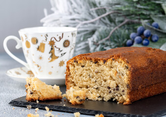 Fresh baked cupcake with cup of tea and christmas decor on light background