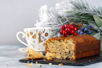 Fresh baked cupcake with cup of tea and christmas decor on light background