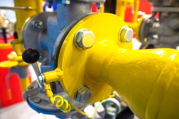 Gas pipes. The yellow pipe is connected to silver. Pipes in the compressor station close-up. Gasification of the enterprise. Equipment at a gas processing station. Large nuts on the pipes. Pipeline