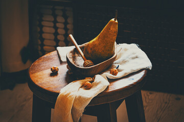 Yellow pear in a wooden plate with honey