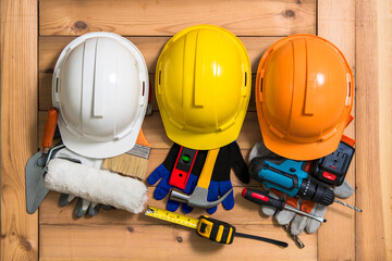 Three helmets of orange, yellow and white for construction and tools.