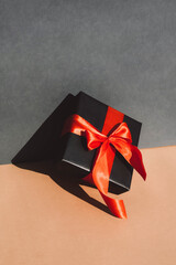 Gift with a large red bow on a gray-beige background.