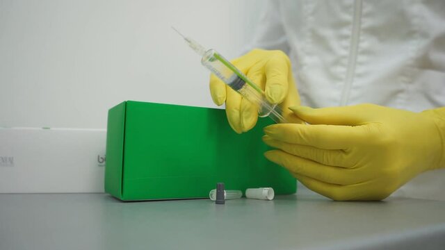 Doctor with syringe. A medical solute in the hands of the doctor.