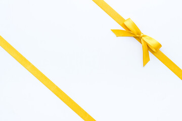 Yellow ribbon with bow isolated. Top view, copy space