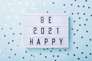 Lightbox with text BE HAPPY 2021 on blue background. Top view. New year celebration. Happy New Year...
