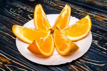 The cut orange lies on a brown wooden background
