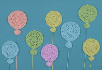 Blue background with handmade crocheted balloons.