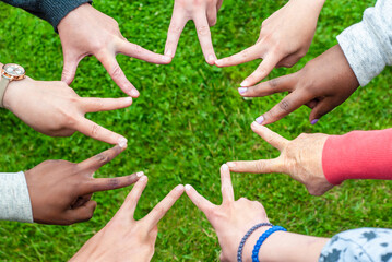 Black and white people forming nine pointed star with their fingers.