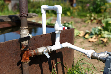 Connection of plastic pipes to the pump and water storage tank. Pumping water using a homemade plumbing.