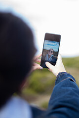 Young woman takes a selfie with her mobile on a mountain surrounded by nature. Woman with sunglasses.