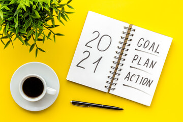 Inspiration concept - New Years goals written in notebook on a table, flat lay
