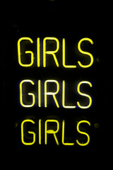 Girls written in neon lights against black background