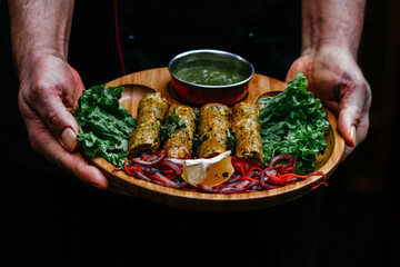 a man holding a plate of kebab