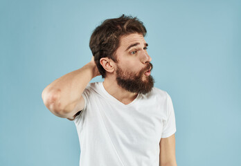 Puzzled man with a beard on a blue background emotions of surprise