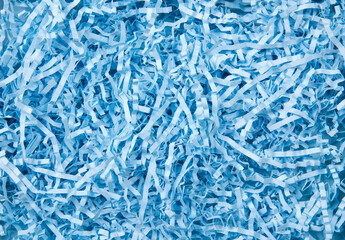 Blue color shredded paper - gift box filler background.