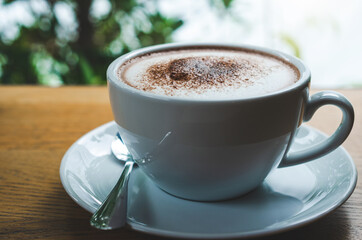closeup coffee cup on wood table bar in restaurant or cafe with copy space. fresh beverage.
