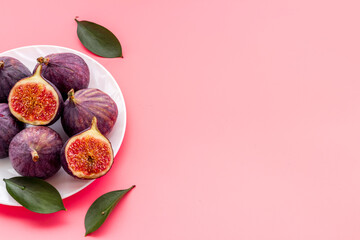 Fresh figs in on a plate with green leaves. Top view