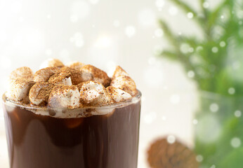 hot cocoa with mini marshmallows with pine branches with Christmas lights of bokeh. Coffee, hot chocolate.