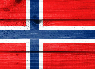 Fototapeta premium Norway flag painted on old wood plank background. Brushed natural light knotted wooden board texture. Wooden texture background flag of Norway