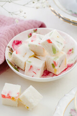 sweet confectionery-Pastila (marshmallows) with candied fruits and black tea in a mug. Tea party in pink style