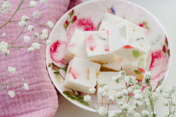 sweet confectionery-marshmallows with candied fruits and black tea in a mug. Tea party at the bright table. close up