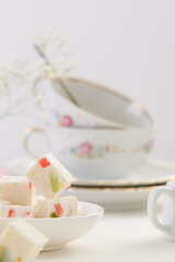 Fototapeta na wymiar sweet confectionery-marshmallows with candied fruits and black tea in a mug. Tea party at the bright table. close up
