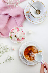 sweet confectionery-Pastila (marshmallows) with candied fruits and black tea in a mug. Tea party in pink style