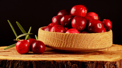 Fresh ripe cranberries in wooden bowl.
