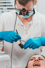 After filling, the dentist removes the excess material from the tooth with a copying tracing paper.
