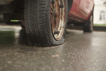 Fototapeta na wymiar Car With Deflated Wheel On Street