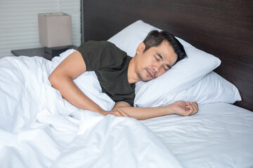 Asian man sleeping at the white bed in a home