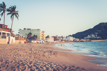 Small beach town in Mexico and waves crashing at sunset